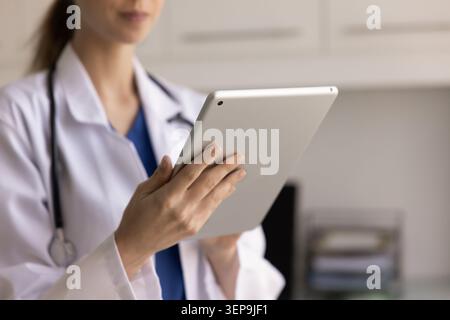Primo piano di un medico donna che tiene in mano una compressa digitale Foto Stock