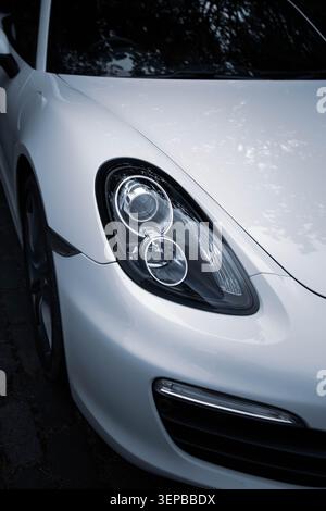 Primo piano del faro Porsche Cayman bianco Foto Stock
