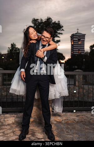 Felice matrimonio di coppia in gara mista all'aperto Foto Stock