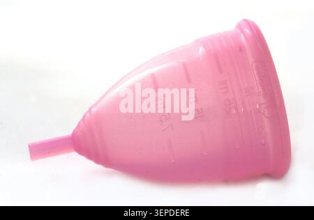 Tazza mestruale rosa riutilizzabile su sfondo bianco Foto Stock