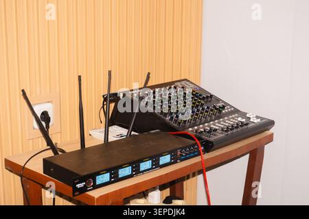 Palu, Indonesia - 10 giugno 2026 : mixer audio professionale seduto in cima a un tavolo di legno. Quattro antenne sono pronte per la connettività wireless. L'unità di controllo nera mostra le letture digitali e le porte di ingresso Foto Stock