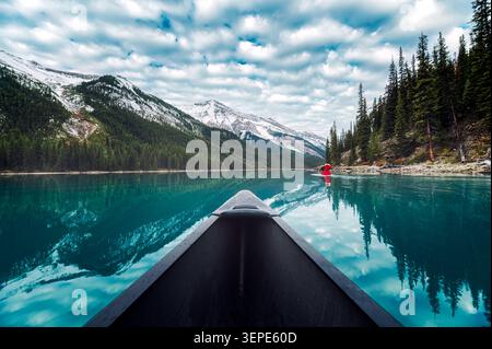 Vista panoramica del canottaggio in canoa nel turchese lago Maligne con le Montagne Rocciose e la foresta di pini nel parco nazionale di Jasper, Alberta, Canad Foto Stock