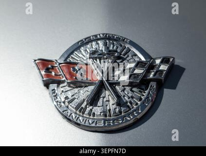 Questa vista ravvicinata mostra un emblema d'argento vintage sul cofano di una classica auto sportiva Corvette Anniversary. Mette in risalto il design e l'artigianato intricati Foto Stock
