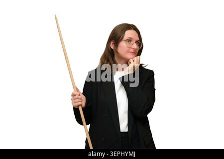 Insegnante donna in occhiali con puntatore in legno che guarda da parte con attenzione. Educatore in tuta nera su sfondo bianco. Studio accademico, classe Foto Stock