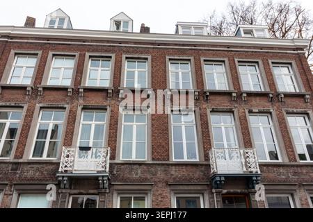 Vista ravvicinata di un edificio residenziale in mattoni con finestre e balconi bianchi, Paesi Bassi Foto Stock