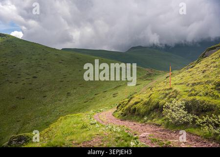Paesaggio di montagna panoramico dal picco Midzor sulla Stara Planina (montagna Vecchia), con verdi pendii escursionistici, creste rocciose, valli boscose, cielo blu, e. Foto Stock