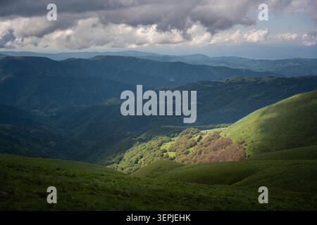 Paesaggio di montagna panoramico dal picco Midzor sulla Stara Planina (montagna Vecchia), con verdi pendii escursionistici, creste rocciose, valli boscose, cielo blu, e. Foto Stock