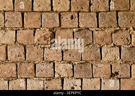 Sfondo di pareti in mattoni di fango in mattoni di mattoni di adobe fatti a mano per una costruzione rustica Foto Stock