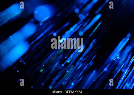 Linee di dati di comunicazione luminose blu a flusso astratto lampeggianti su sfondo scuro Foto Stock
