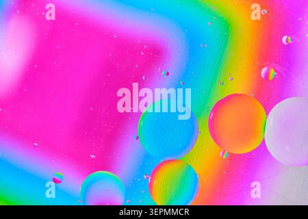 Foto macro di grandi sfere di olio con riflessi di gradiente arcobaleno su sfondo luminoso Foto Stock
