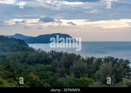 Isola di Koh Tarutao con vegetazione lussureggiante e calme acque oceaniche. La fitta foresta incontra il mare nel Parco Nazionale di Tarutao. Foto Stock