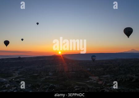 La splendida vista delle mongolfiere che si innalzano all'alba in Cappadocia. Foto Stock