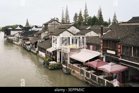Tradizionali edifici lungo il fiume che si riflettono lungo un canale nell'antica città di Zhujiajiao Foto Stock