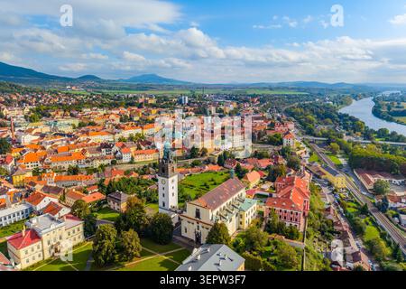 Un drone cattura una splendida vista aerea della cattedrale di Santo Stefano circondata da edifici storici a Litomerice, Cechia. L'architettura vibrante contrasta con i paesaggi verdi. Foto Stock