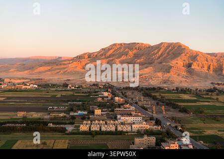 Vista aerea dei Colossi di Memnon tra i terreni agricoli della valle del Nilo, con le montagne tebane vicino alla Valle dei Re visibili da un angolo diverso. Foto Stock
