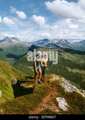 Coppia escursioni in Norvegia amici uomo e donna arrampicata montagne a Meloy, stile di vita sano attivo vacanze estive viaggio tour all'aperto fidanzato An Foto Stock