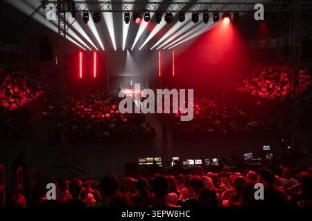 Esibizione sul palco di concerti con faretti spettacolari, luci rosse, grande pubblico seduto che guarda la cantante. Foto Stock