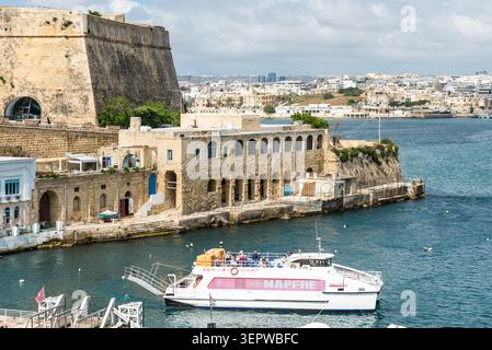 La Valletta, Malta - 16 maggio 2025: Il traghetto passeggeri tra Sliema e la Valletta naviga lungo lo storico lungomare, circondato da calcare per Foto Stock