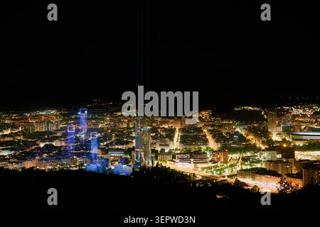 06-12-2026, Bilbao, Bizkaia, città di notte, che mostra un'ampia vista panoramica di edifici illuminati, strade e torre Iberdrola Foto Stock