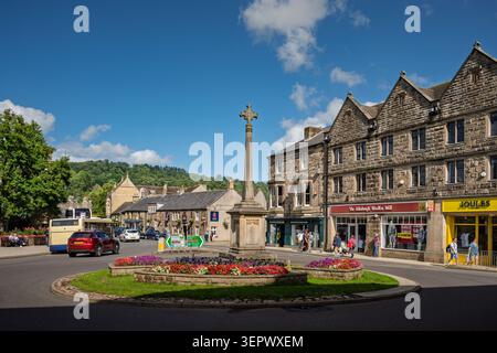 Vista estiva su Rutland Square, guardando verso gli edifici storici in pietra e il memoriale di guerra centrale a Bakewell, Peak District Foto Stock