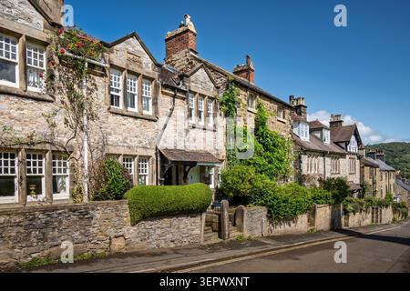 Case terrazzate in pietra del Derbyshire con siepi verdi su North Church Street a Bakewell, Peak District National Park, Regno Unito Foto Stock