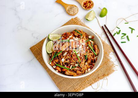 Spaghetti tailandesi con gamberetti, tofu e lime in ciotola su sfondo di marmo bianco con spazio copia Foto Stock