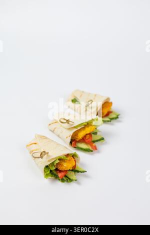Tre deliziosi involtini di pollo con verdure fresche e lattuga, serviti con spiedini di bambù Foto Stock