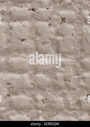 Vista macro di un pannello in polistirene espanso beige che mostra cordoni rotondi irregolari fusi con cuciture visibili, piccole tasche d'aria e un leggero strato Foto Stock