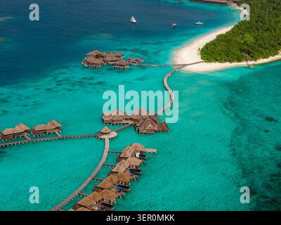 Vista aerea del resort delle Maldive con ville sull'acqua e spiaggia Foto Stock