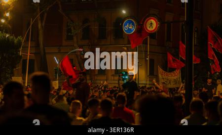 Tirana, Albania – 17 giugno 2026: Manifestanti sagomati e bandiere albanesi sono visti durante una manifestazione notturna a Tirana. Foto Stock
