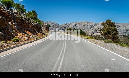 Strada tortuosa a due corsie che attraversa i monti Dikti nella parte orientale di Creta, Grecia Foto Stock