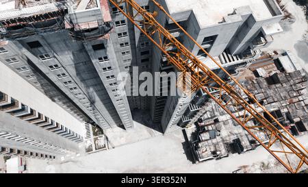 Veduta dall'alto verso il basso della Tower Crane sopra l'alto edificio in costruzione Foto Stock