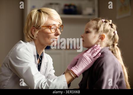 Pediatra donna che esamina la ragazza durante la visita benessere dei bambini Foto Stock