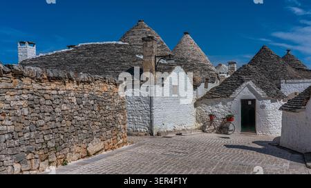 Uno scorcio dei tradizionali trulli nel quartiere di Aia piccola, con i loro caratteristici tetti conici in pietra e le pareti dipinte di bianco. Alberobello Foto Stock
