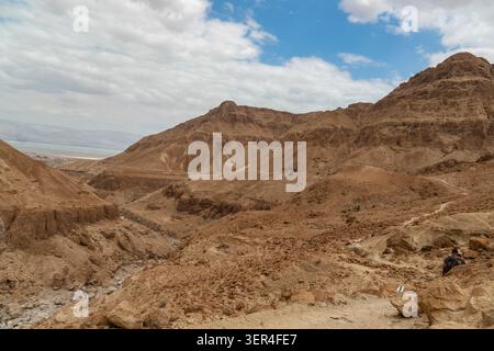 Israele. Una vista del deserto di Giudea, che mostra montagne aride e secche, creste di canyon e gole profonde scavate da alluvioni improvvise. Il Mar Morto sullo sfondo. Foto Stock