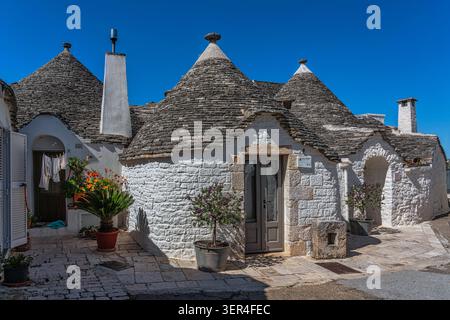 Uno scorcio dei tradizionali trulli nel quartiere di Aia piccola, con i loro caratteristici tetti conici in pietra e le pareti dipinte di bianco. Alberobello Foto Stock