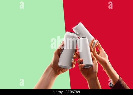 Tre lattine bianche che tostano su sfondo verde e rosso. Foto Stock
