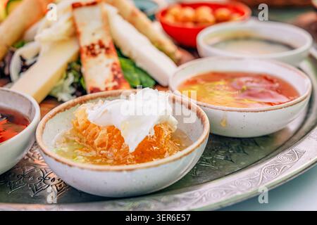 Piatto tradizionale turco per la colazione con vari formaggi, marmellate, miele, olive e spalmabili, servita su un vassoio ornamentale Foto Stock