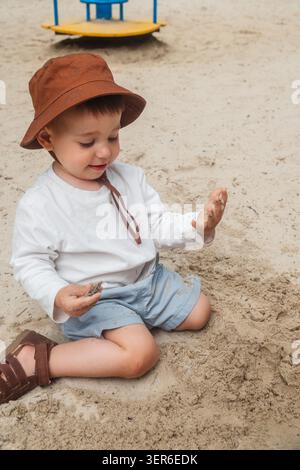 Bambino al Sun Hat nel Sandy Playground Park Foto Stock