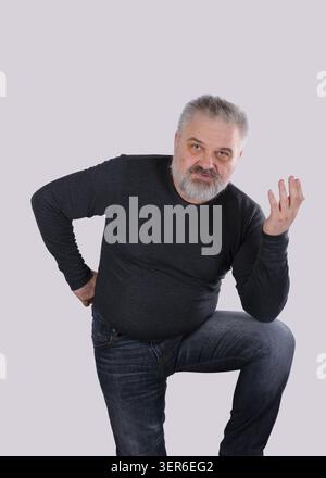 Ritratto di un uomo barbuto maturo che gestiva con la mano mentre poneva una domanda, esprimeva confusione, dubbi o cercava una soluzione. su una luce Foto Stock
