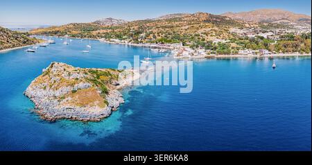 Gumusluk, Bodrum, goditi una calda giornata estiva, mostrando l'Isola dei conigli e gli yacht privati che ancorano nel mare turchese dell'Egeo Foto Stock