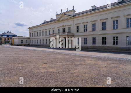 La facciata di uno storico palazzo bianco con finestre multiple adagiate su un piazzale di ghiaia nei Giardini di Herrenhausen, Hannover, Germania. Foto Stock