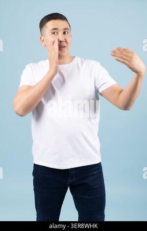 Curioso, giovane e bello, che punta il dito da parte in uno spazio vuoto per le copie Foto Stock