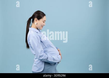 Donna che tiene lo stomaco e sorride Foto Stock