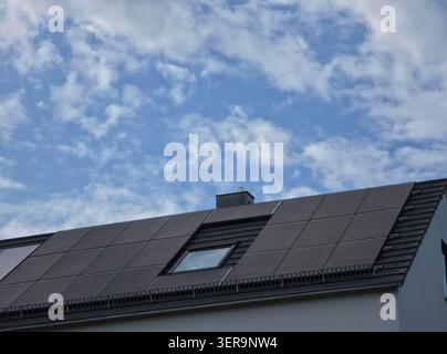 tetto moderno completamente rivestito con pannelli fotovoltaici che massimizzano la produzione di energia pulita sotto il cielo soleggiato Foto Stock