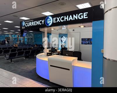 International Currency Exchange, Airport - Un ufficio di cambio valuta con un design moderno e luci blu, situato in un terminal aeroportuale con posto a sedere Foto Stock