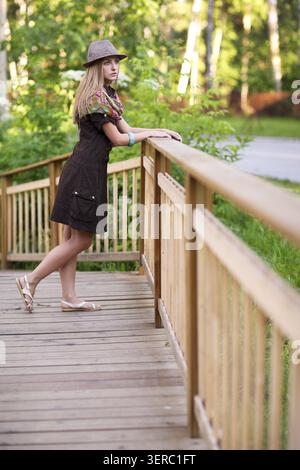 Giovane bella donna su un piccolo ponte di legno Foto Stock