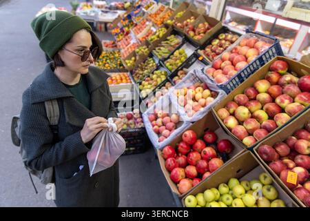 Un'ampia dose di donna al colorato mercato della frutta Foto Stock