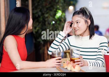 Amici che si godono il caffè. Donne rilassate impegnate in una conversazione amichevole con un'atmosfera calda Foto Stock