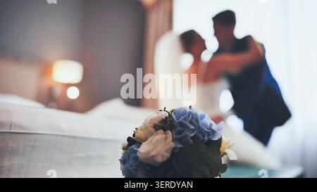 Bouquet nuziale con silhouette morbida di sposo e sposo in una camera romantica. Foto Stock